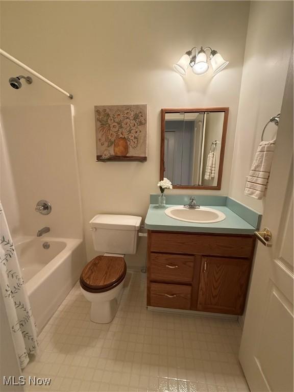 bathroom with shower / tub combo with curtain, vanity, toilet, and tile patterned floors