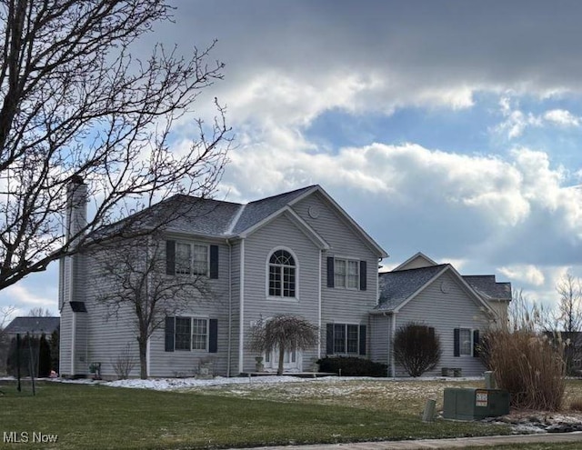 view of front facade with a chimney and a front yard