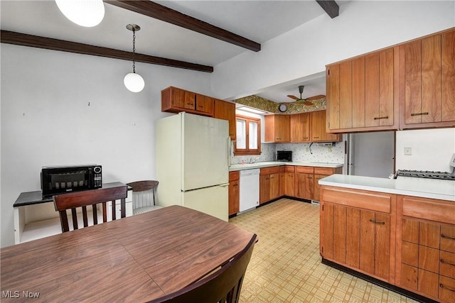 kitchen with white appliances, light countertops, brown cabinetry, light floors, and beamed ceiling