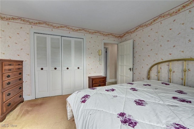 bedroom with wallpapered walls, a closet, and light colored carpet