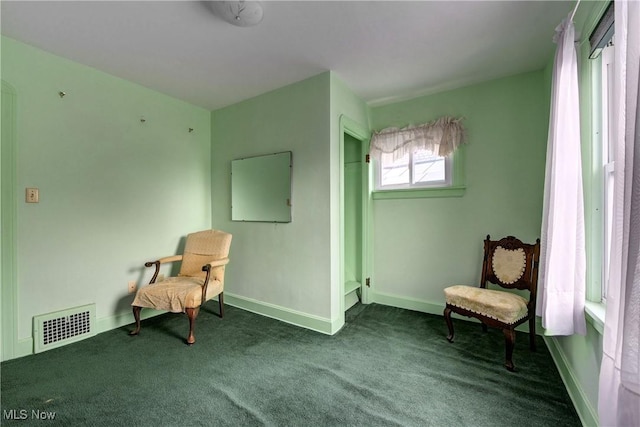 living area with carpet floors, visible vents, and baseboards