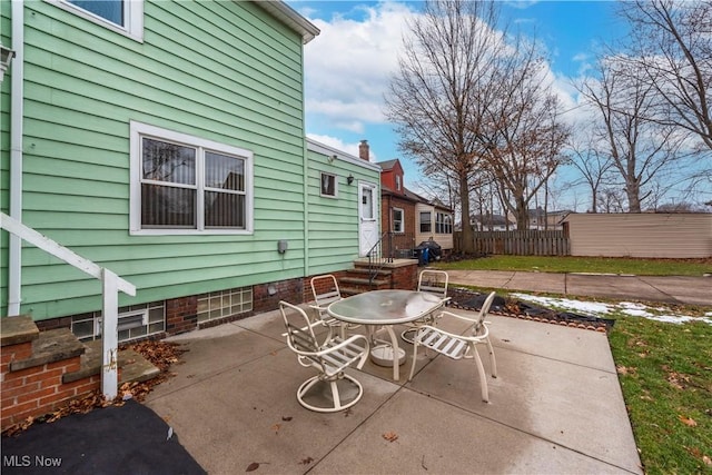 view of patio with outdoor dining space and fence