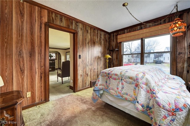 carpeted bedroom with wood walls, a textured ceiling, visible vents, and crown molding