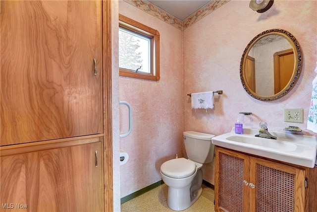 bathroom featuring vanity, toilet, and baseboards