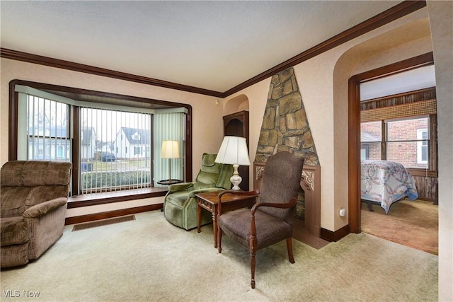 sitting room featuring carpet, a wealth of natural light, and crown molding