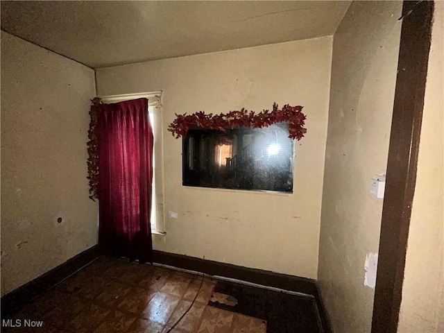 empty room with baseboards and tile patterned floors