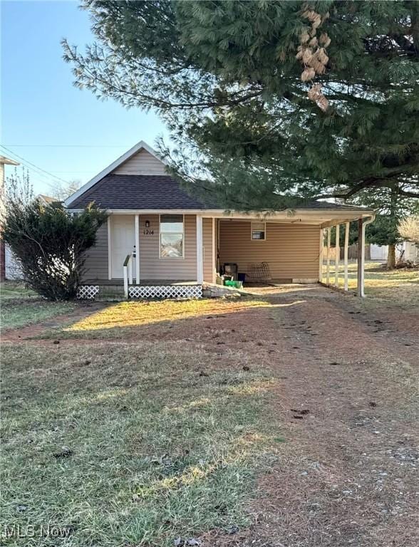 view of front of home with a shingled roof, entry steps, and an attached carport