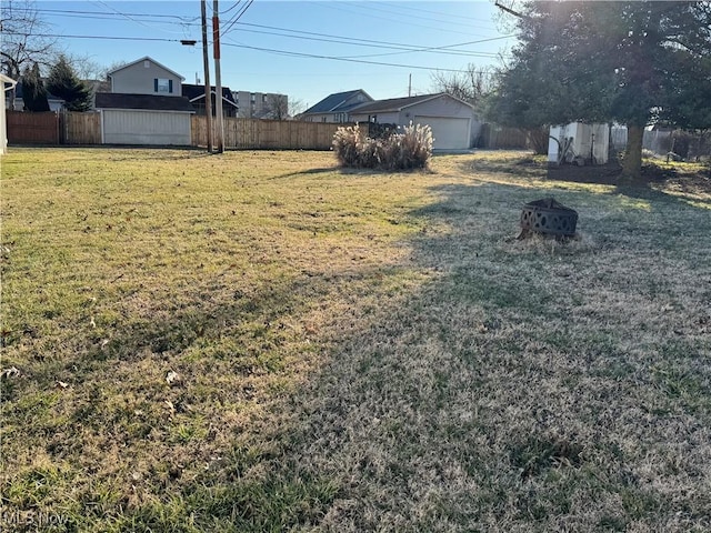 view of yard with a fire pit and fence