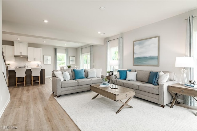 living room with baseboards, light wood-style flooring, and recessed lighting