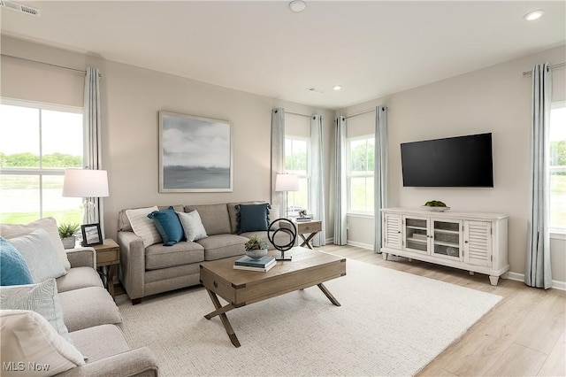 living room with light wood-style floors, baseboards, visible vents, and recessed lighting