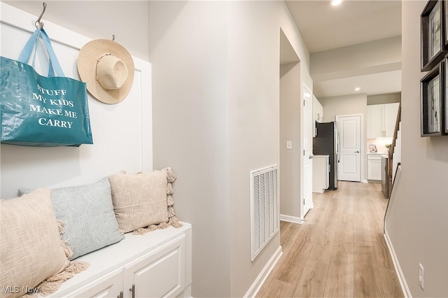 hallway with recessed lighting, baseboards, visible vents, and light wood finished floors