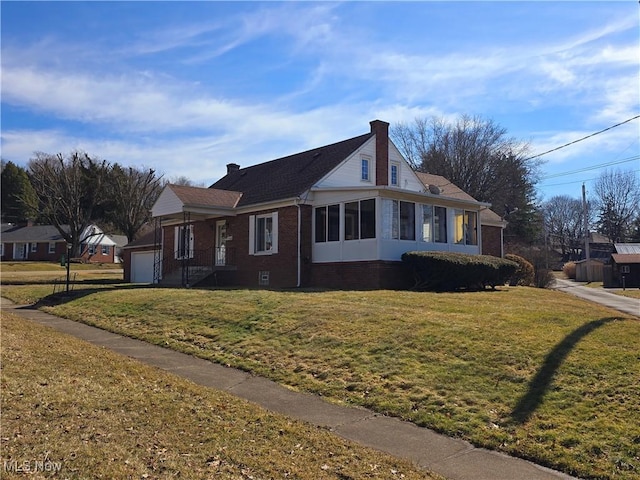 view of side of property featuring a chimney, brick siding, a lawn, and an attached garage