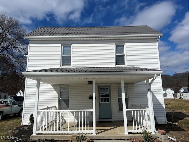 traditional home with covered porch and metal roof