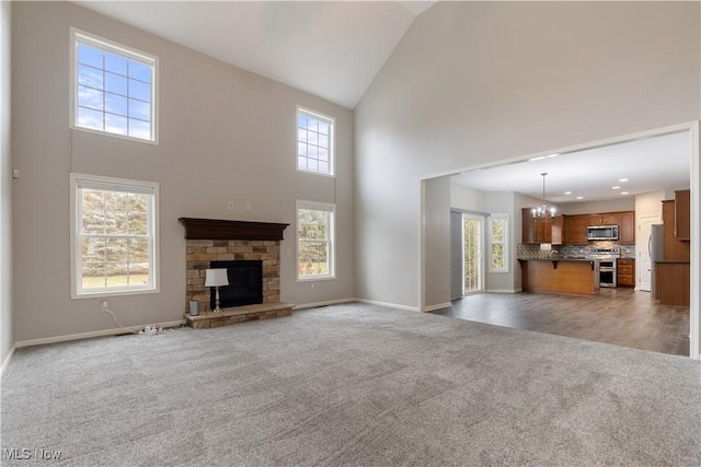 unfurnished living room featuring carpet floors, plenty of natural light, and a stone fireplace