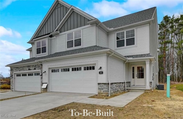 view of front of property with a garage, central AC unit, concrete driveway, stone siding, and board and batten siding