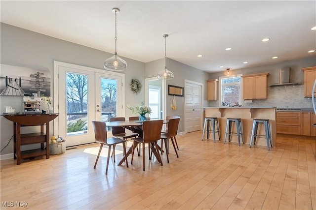 dining area with baseboards, french doors, light wood finished floors, and recessed lighting