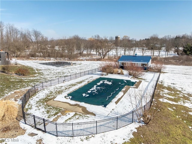 snow covered pool featuring a fenced in pool and fence