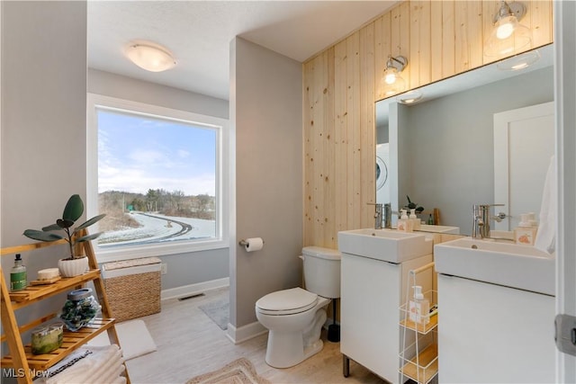 bathroom featuring visible vents, toilet, vanity, wood finished floors, and baseboards