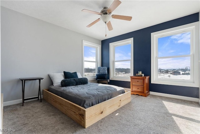 carpeted bedroom with a ceiling fan and baseboards