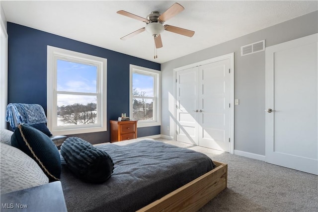 bedroom featuring a ceiling fan, carpet flooring, visible vents, and baseboards