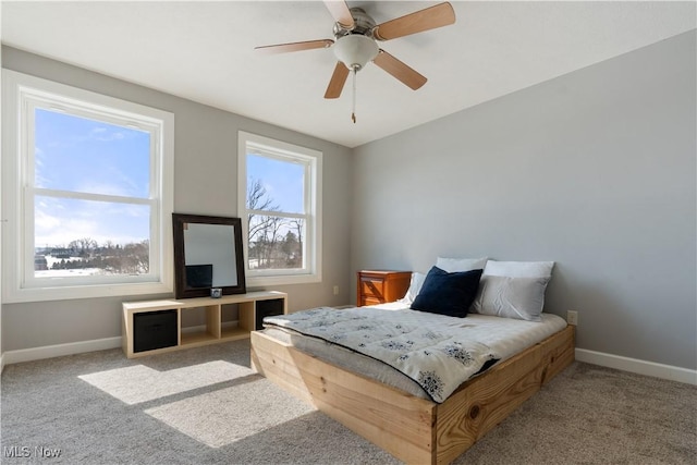 carpeted bedroom with baseboards and a ceiling fan