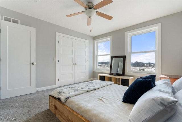 carpeted bedroom featuring baseboards, visible vents, ceiling fan, and a closet