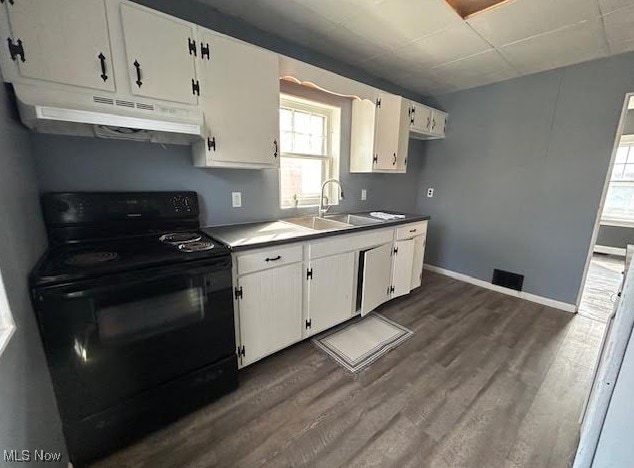 kitchen with black electric range, dark wood-type flooring, white cabinetry, a sink, and under cabinet range hood