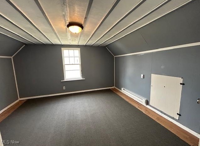 additional living space featuring a baseboard heating unit, vaulted ceiling, and baseboards