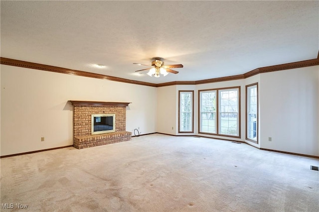 unfurnished living room featuring baseboards, ornamental molding, carpet, a textured ceiling, and a fireplace