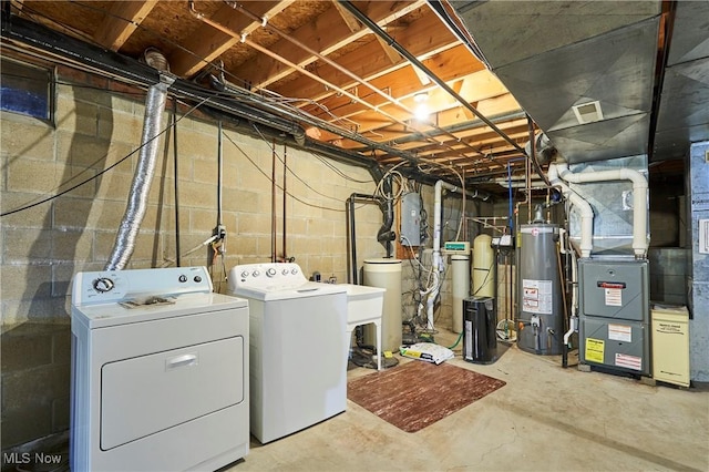 laundry room featuring laundry area, water heater, washer and clothes dryer, and a sink