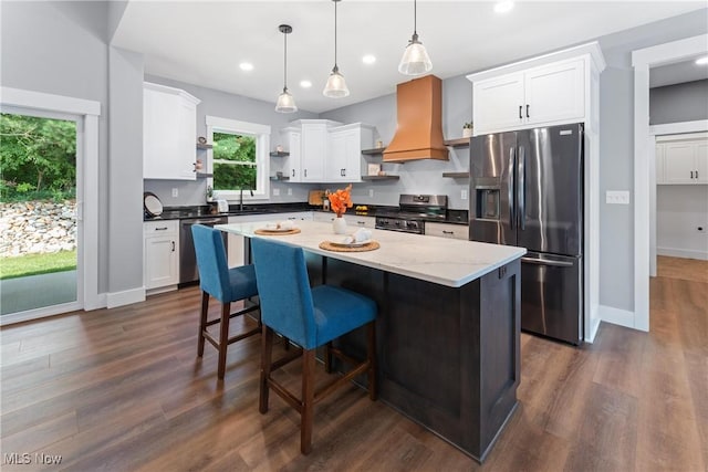 kitchen with custom range hood, appliances with stainless steel finishes, dark wood-style flooring, open shelves, and a sink