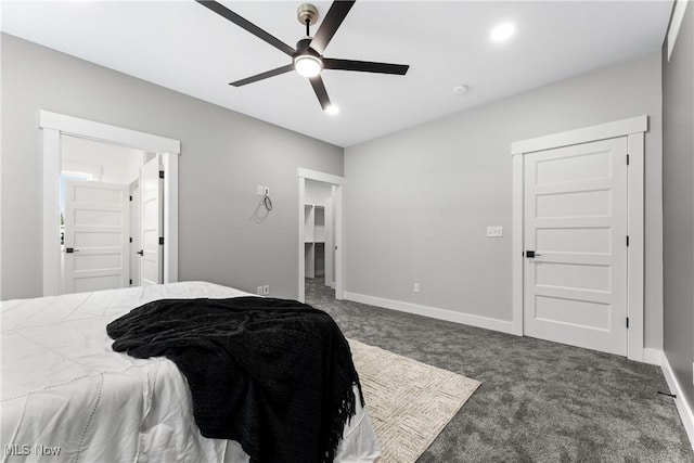 carpeted bedroom with a walk in closet, a closet, ceiling fan, and baseboards