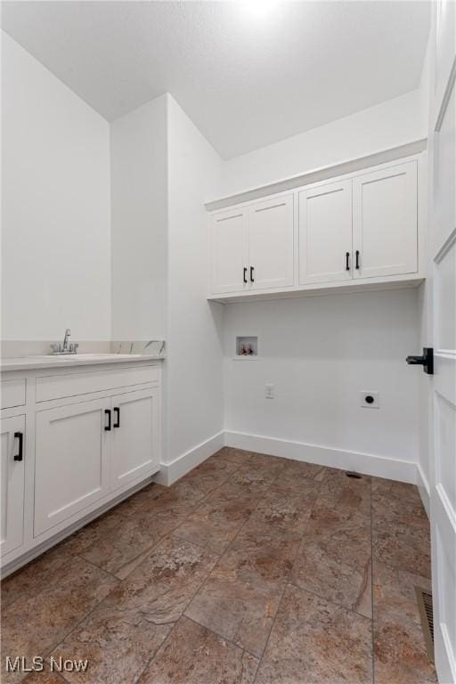 laundry area with hookup for a washing machine, hookup for an electric dryer, a sink, baseboards, and cabinet space