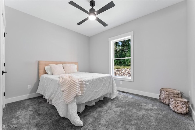 carpeted bedroom featuring baseboards and a ceiling fan