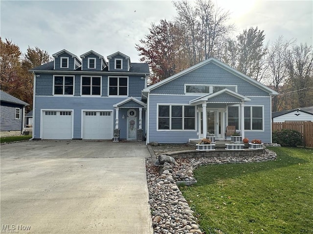 view of front of property featuring a garage, a front yard, concrete driveway, and fence