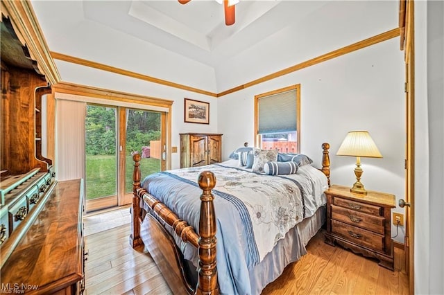 bedroom featuring a ceiling fan, access to outside, a raised ceiling, and wood finished floors