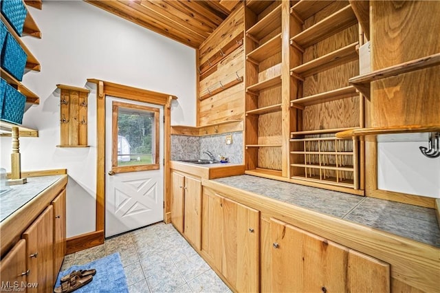 kitchen with tile countertops, a sink, wood ceiling, open shelves, and tasteful backsplash