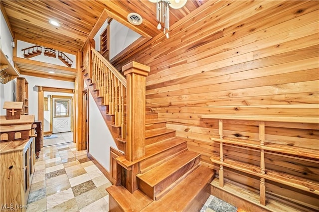 stairway featuring wood walls, wooden ceiling, visible vents, and recessed lighting