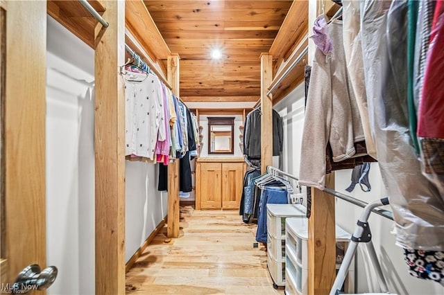 walk in closet with light wood finished floors