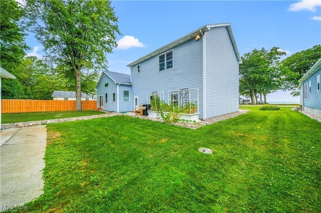 back of house with a yard and fence