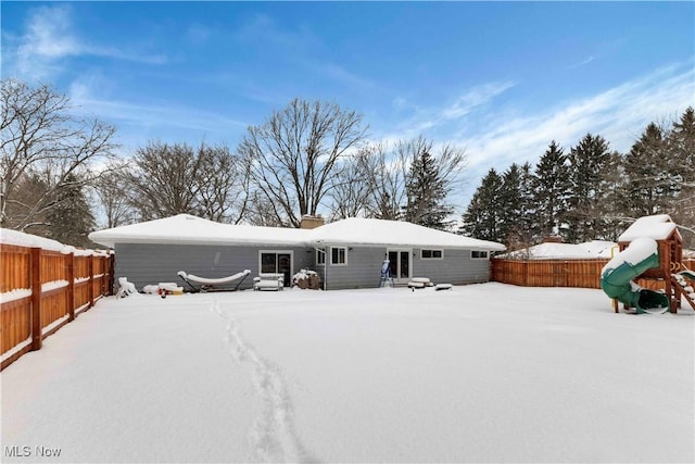 snow covered house with fence private yard