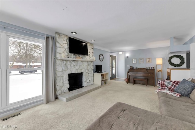 carpeted living room featuring a fireplace and visible vents