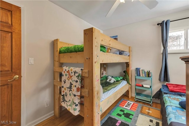 bedroom with ceiling fan, baseboards, and wood finished floors