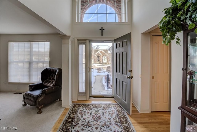 entrance foyer with plenty of natural light, decorative columns, visible vents, and light wood-style flooring