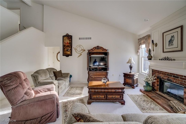 living area with carpet floors, a brick fireplace, visible vents, and high vaulted ceiling