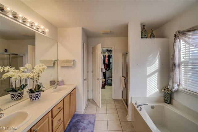 bathroom featuring a stall shower, tile patterned flooring, and a sink