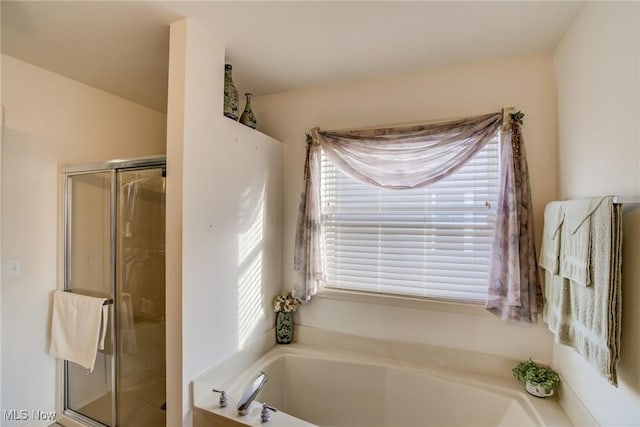 bathroom featuring a stall shower and a bath