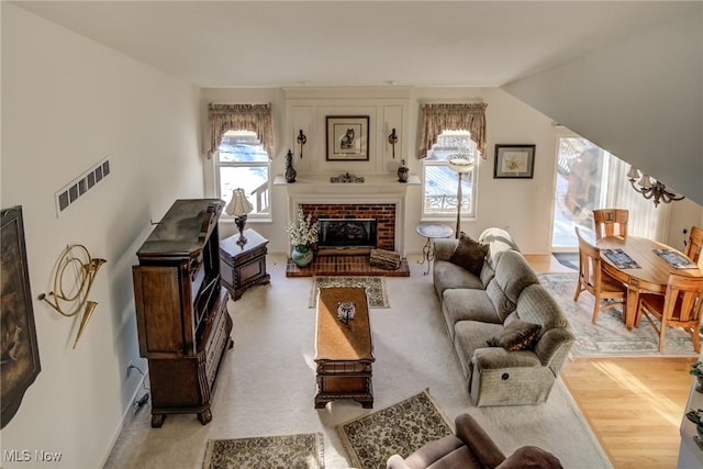 living area featuring plenty of natural light, a fireplace, and visible vents