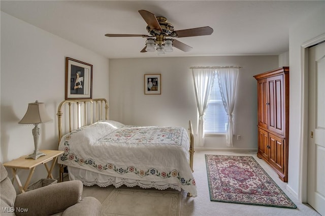 carpeted bedroom with ceiling fan and baseboards