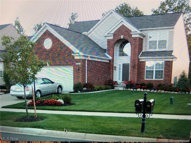 traditional-style house featuring an attached garage, driveway, brick siding, and a front yard